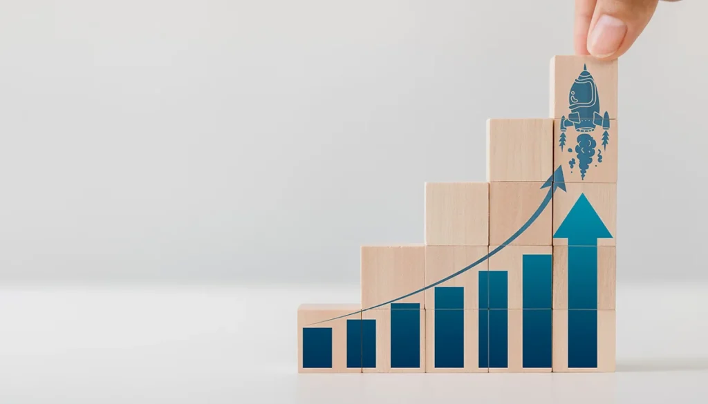 A stack of blocks going upward painted with a blue arrow, showing the concept of business growth from digital marketing