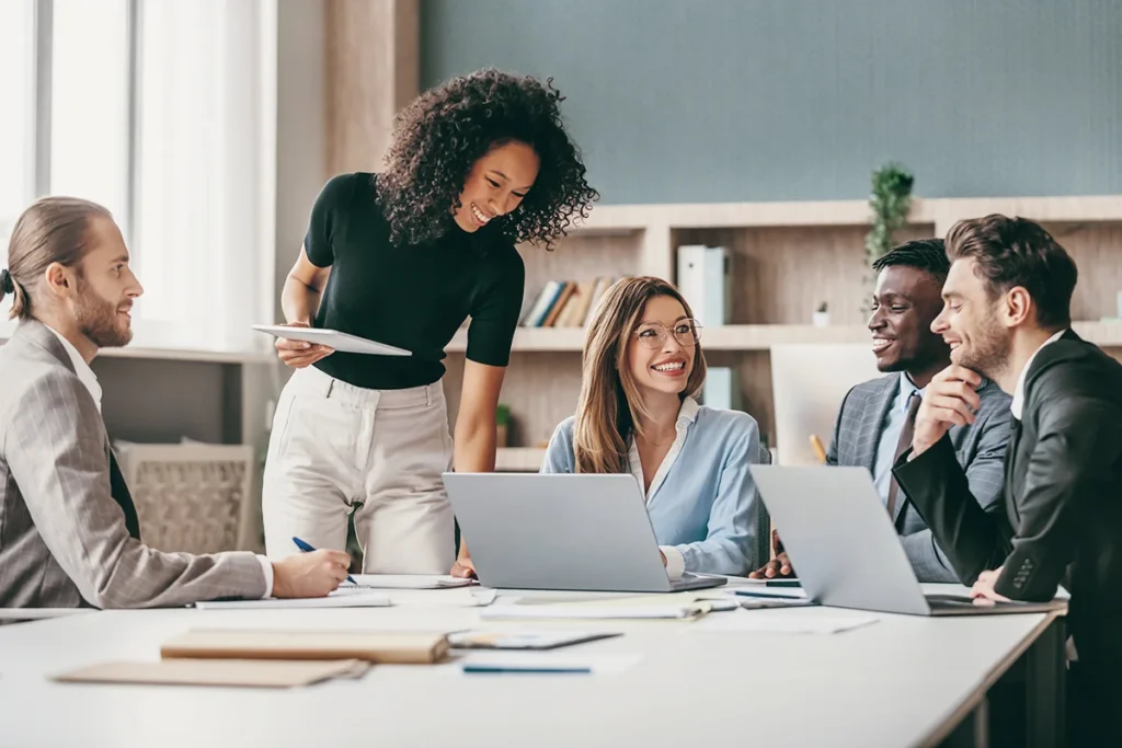 A digital marketing team collaborating at a desk with laptops